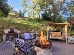An outdoor seating area with a fire pit, benches, and a pergola. - The Hideaway (Shepton Mallet)