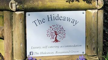 A sign for 'The Hideaway' indicating luxury, self-catering accommodation.