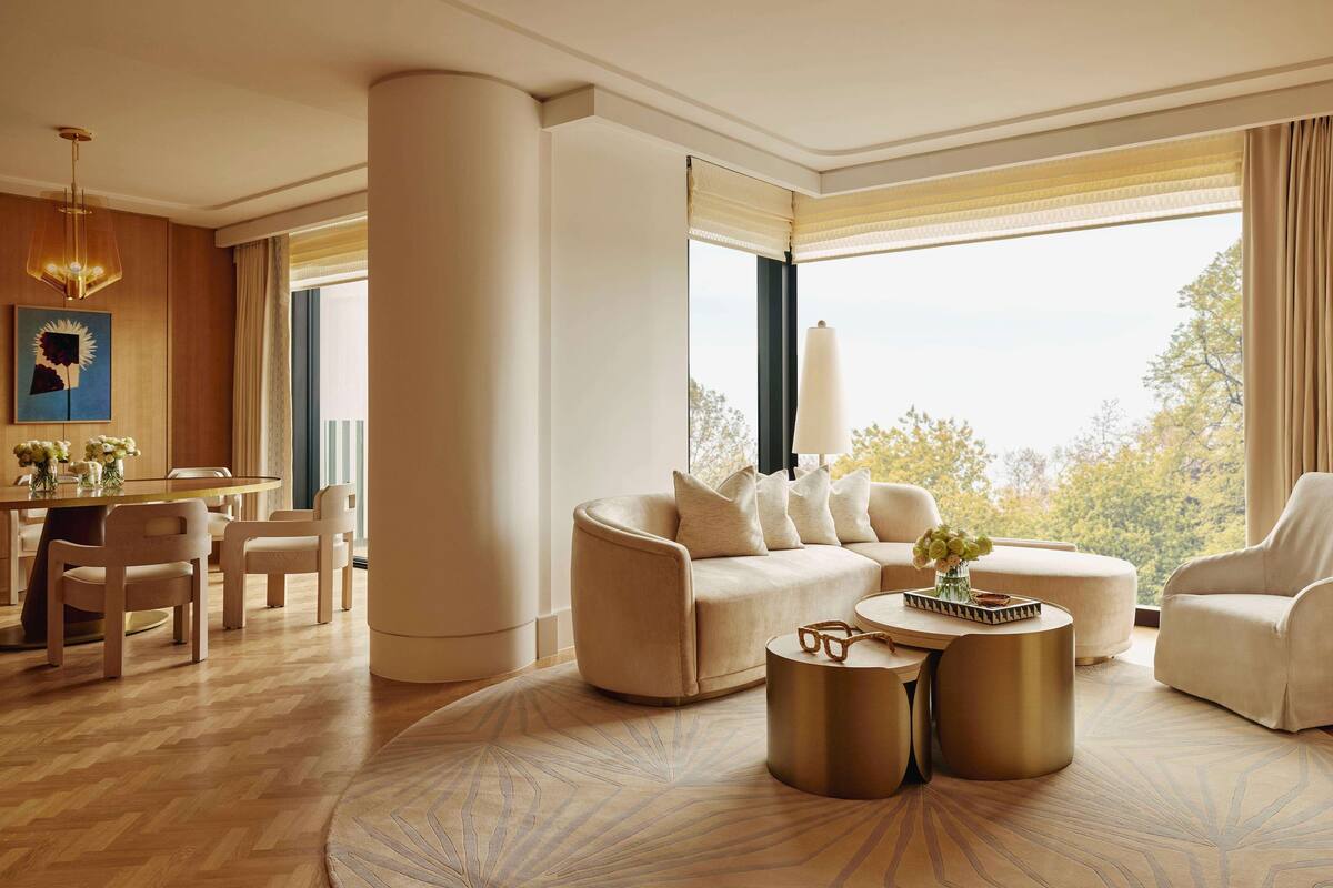A spacious living room with a large window, a round coffee table, and a sofa.