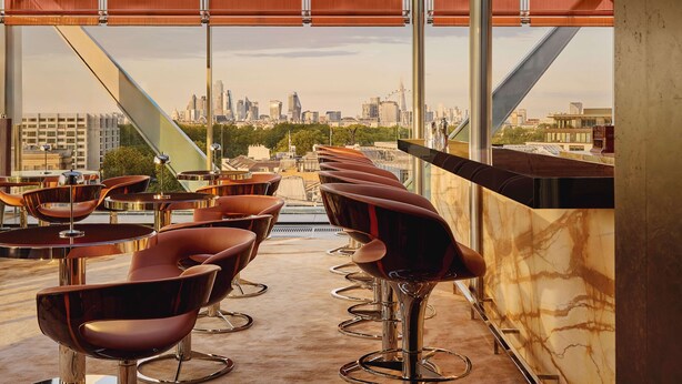 A rooftop bar with modern bar stools and a city view. - The Emory, Maybourne (London)