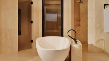 A modern bathroom with a large freestanding bathtub, a separate sink, and a shower area.