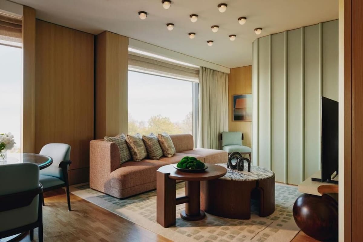 A modern living room with a sofa, a round coffee table, and a television.