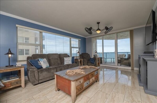 A spacious living room with a sofa, coffee table, and a television.