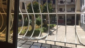 Un cortile con un cancello in metallo, circondato da edifici con balconi e finestre.