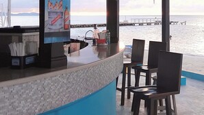 A bar area with a view of the sea, featuring a counter with a sign advertising a red stripe bucket for $3.50. - Pink Hibiscus Villa (Montego Bay)