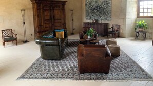 A spacious living room with a leather sofa, a wooden cabinet, and a large abstract painting on the wall. - Les Trois-Moutiers (Les-Trois-Moutiers)