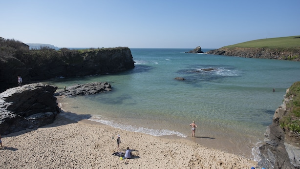 A beach with clear water, rocky cliffs, and a grassy hill. - Sunshine Cottage -  a cottage that sleeps 4 guests  in 2 bedrooms (Padstow)