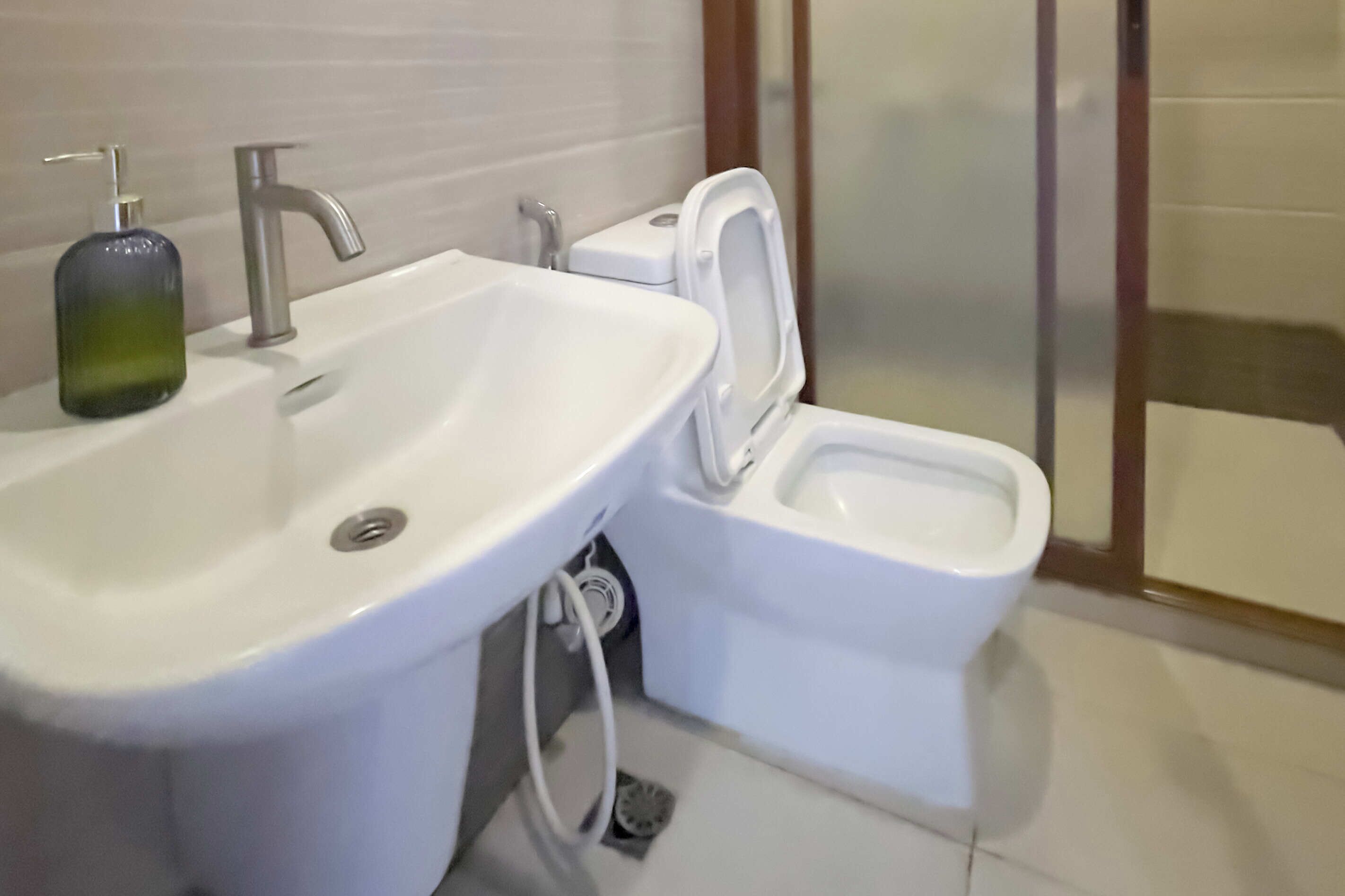 A bathroom with a white sink, a toilet, and a shower area.