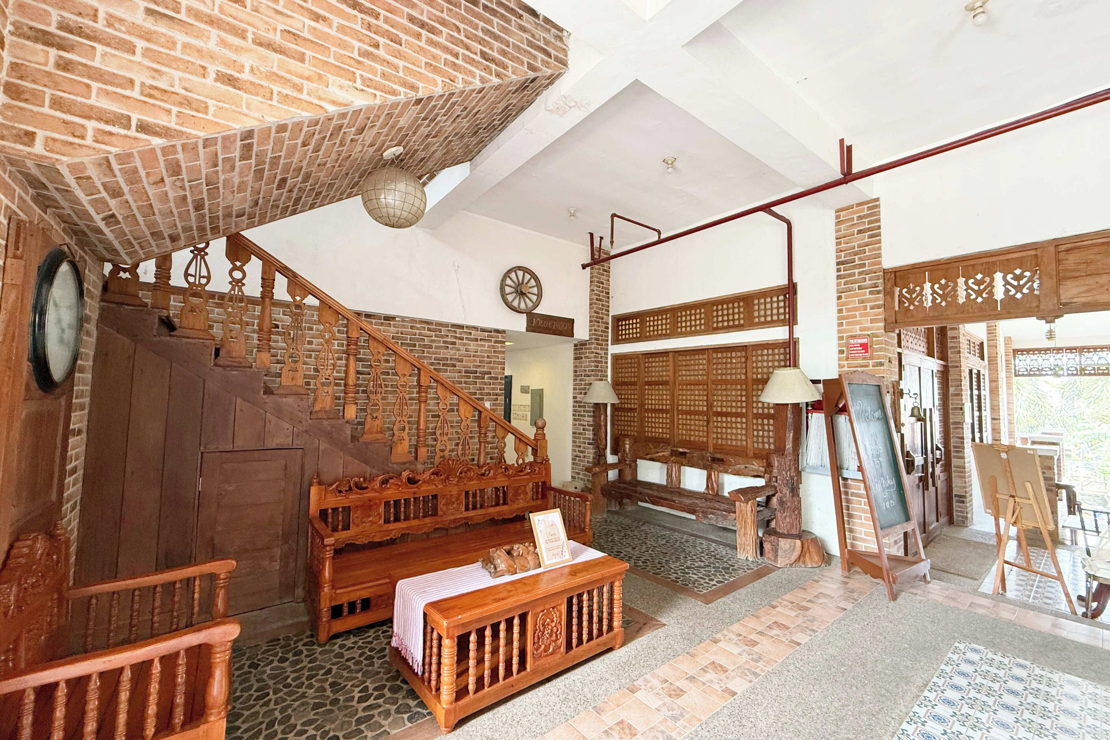 Um quarto amplo com escada de madeira, um banco de madeira e uma mesa com um aviso.