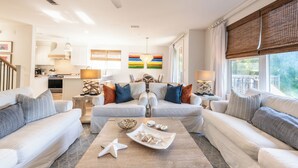 A spacious living room with two sofas, a coffee table, and a kitchen in the background. - Sandestin, Baytowne Wharf, Golf Cart, Pool (Miramar Beach)