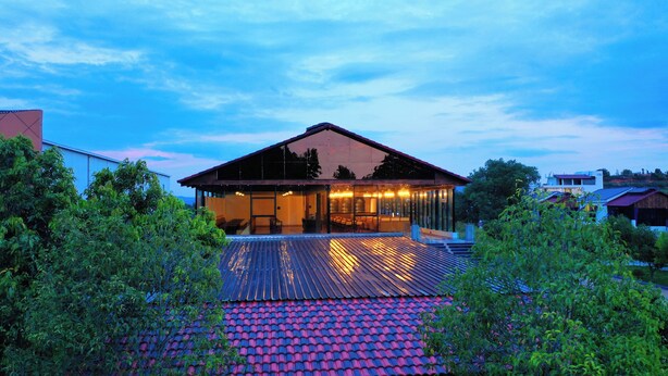 A modern house with a large glass facade, a spacious deck, and a red-tiled roof. - Lake Valley Resort and Spa, Tirupati  (Chinnagottigallu)