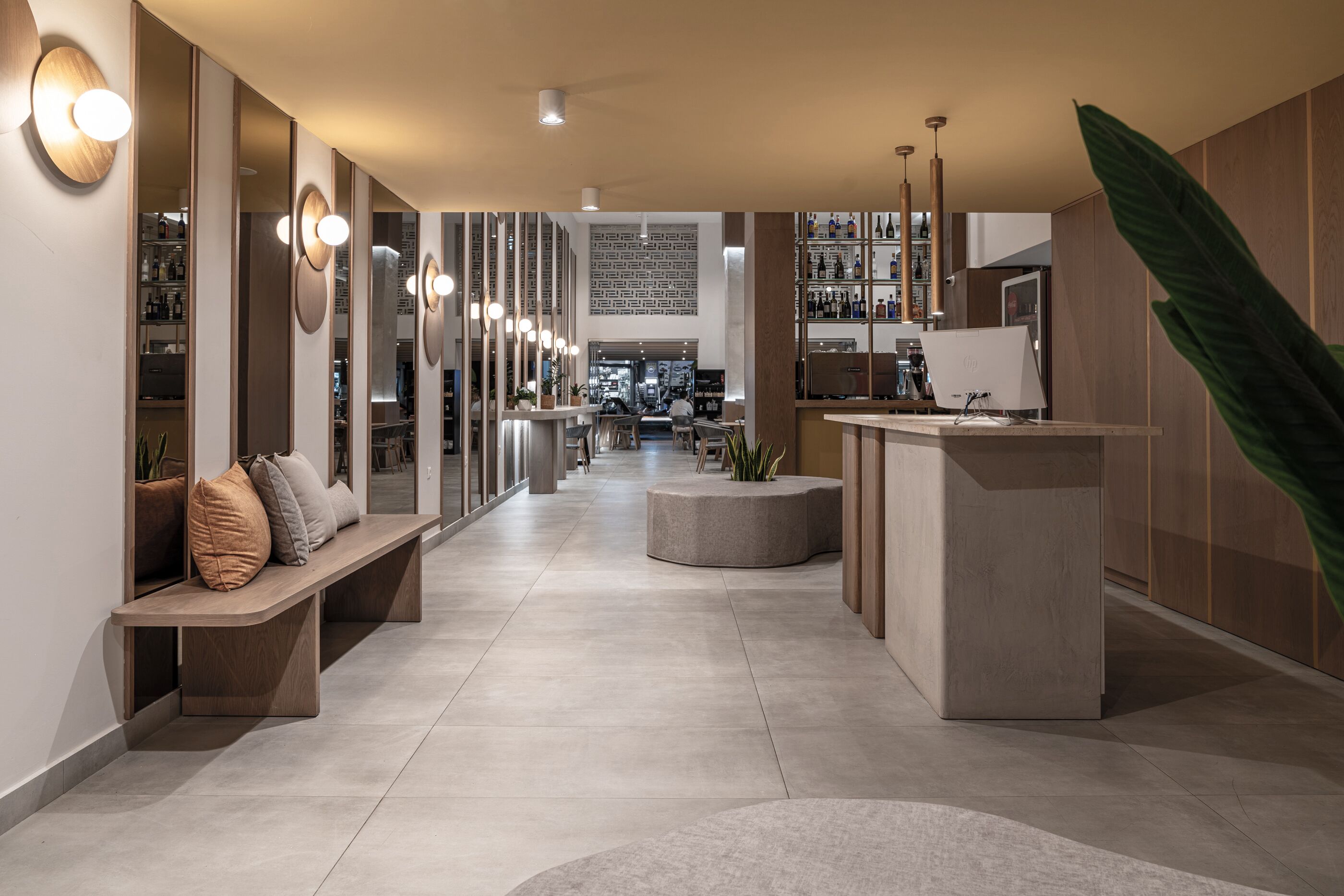 Un intérieur moderne avec un long couloir, un espace salon et un bar.