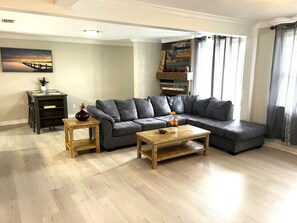 A living room with a sectional sofa, a coffee table, and a small side table.