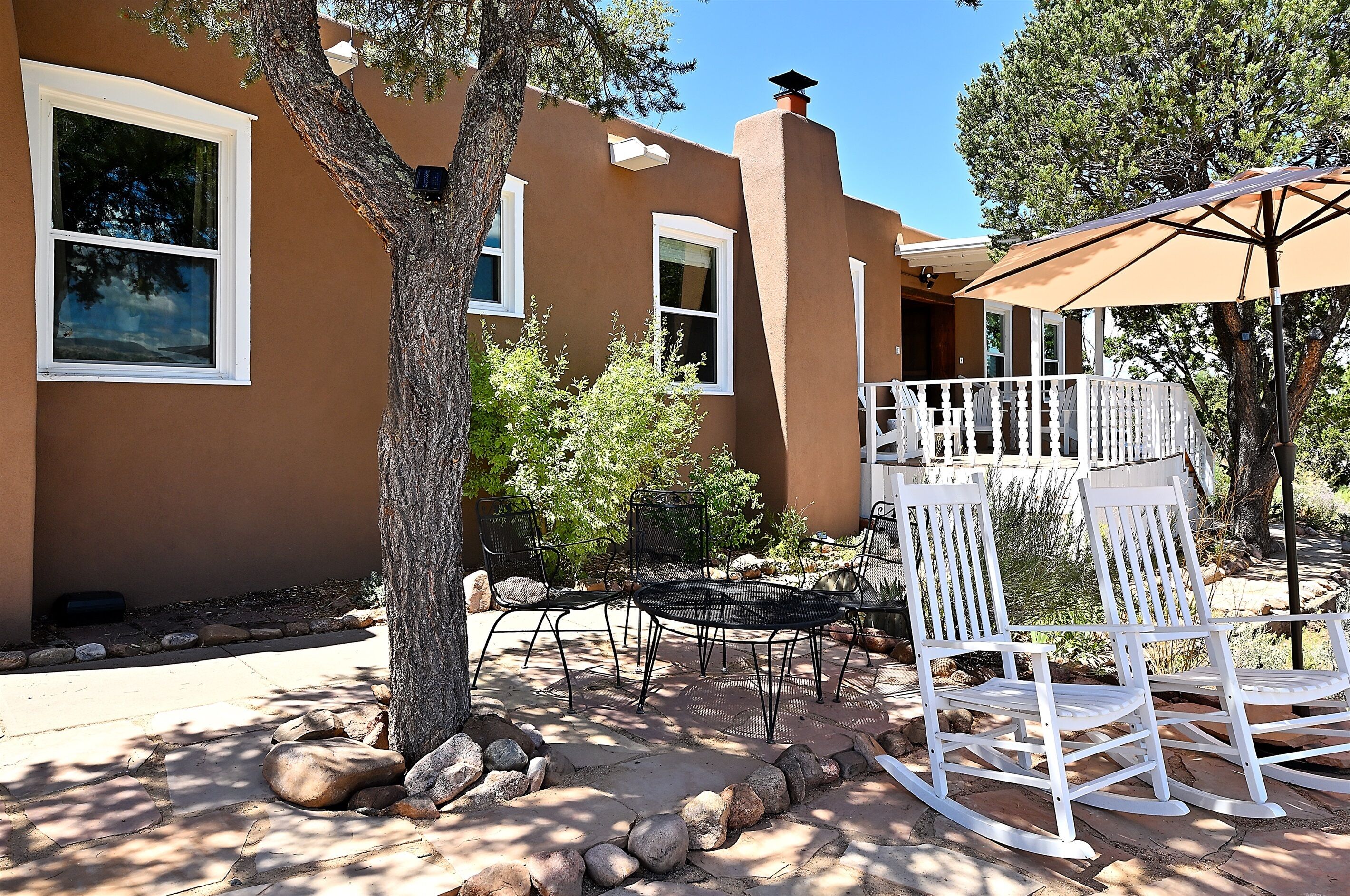 Une maison dotée d’un patio aménagé avec des meubles d’extérieur et une pergola.