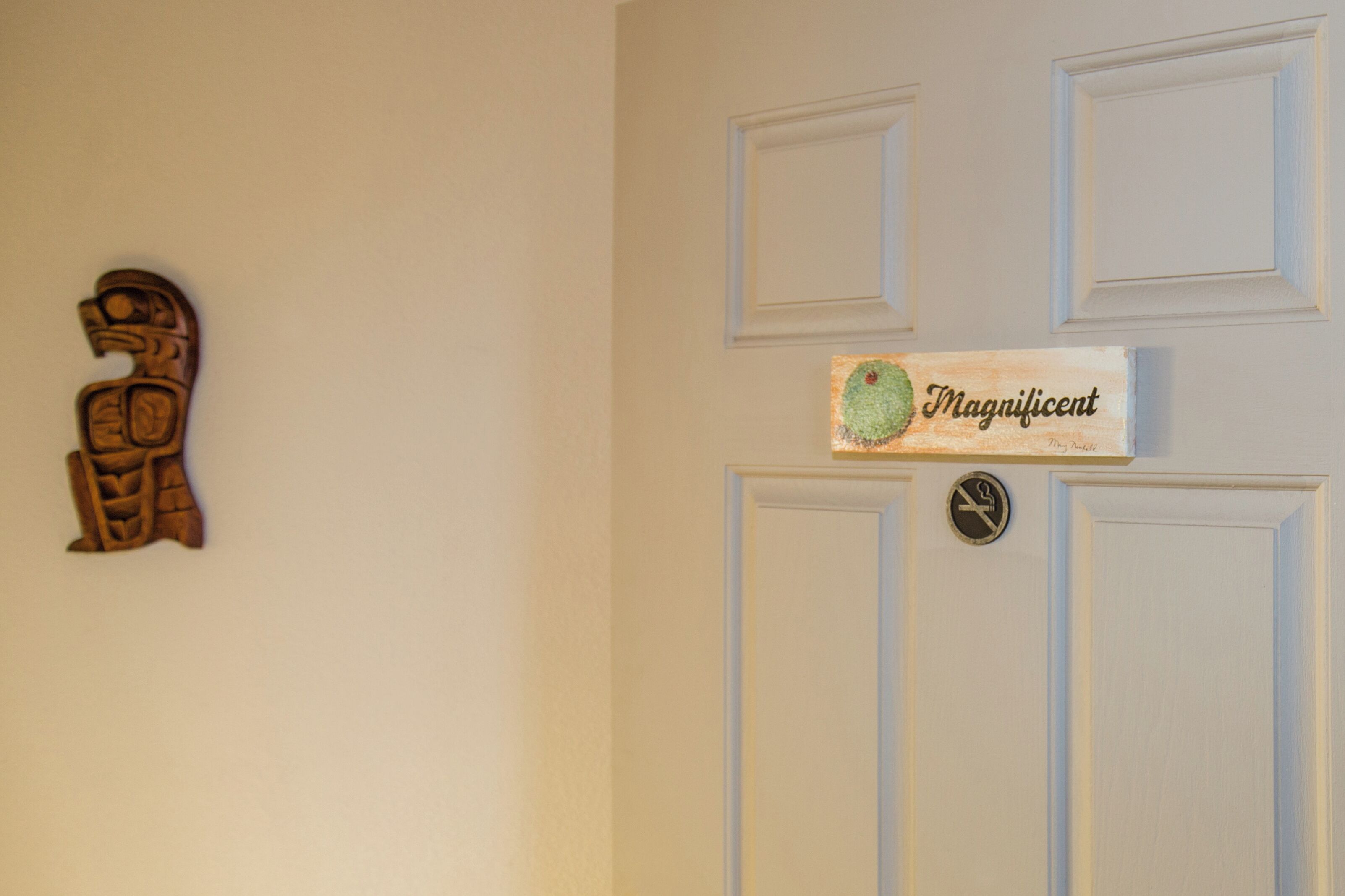 Eine Tür mit einer HolzSchnitzerei und einem Schild mit der Aufschrift 'Magnificent'.