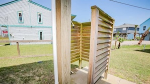 Una estructura de pergola de fusta en una zona residencial, amb cases al fons.