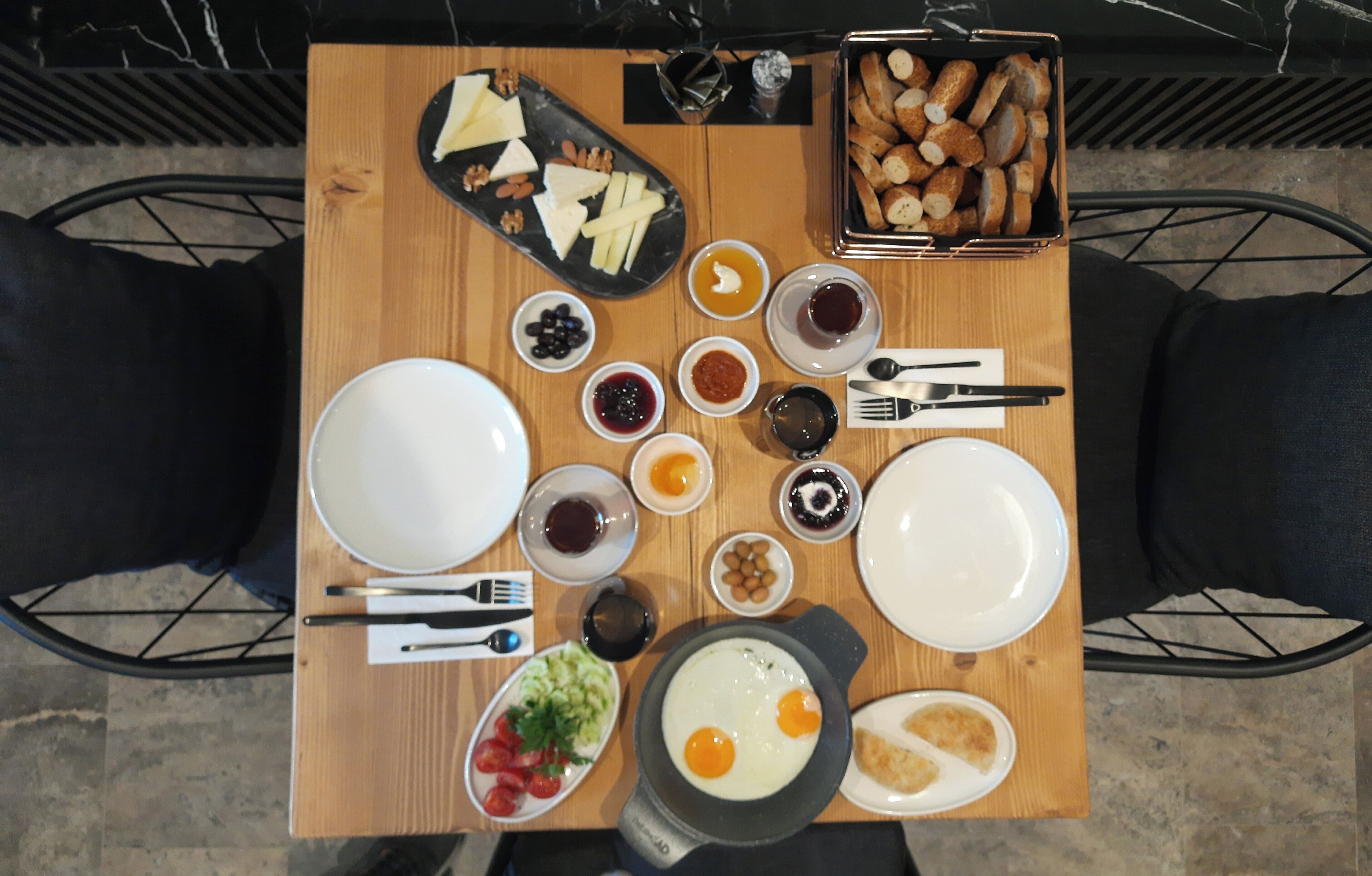 A breakfast table with various food items, including eggs, bread, and fruits.