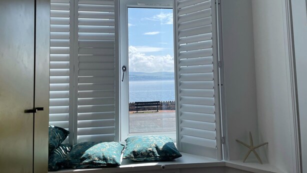A room with a bay window, a bench outside, and a starfish decoration.