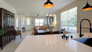 Una cocina amplia con una isla grande, armarios de madera oscura y un comedor con mesa y sillas.