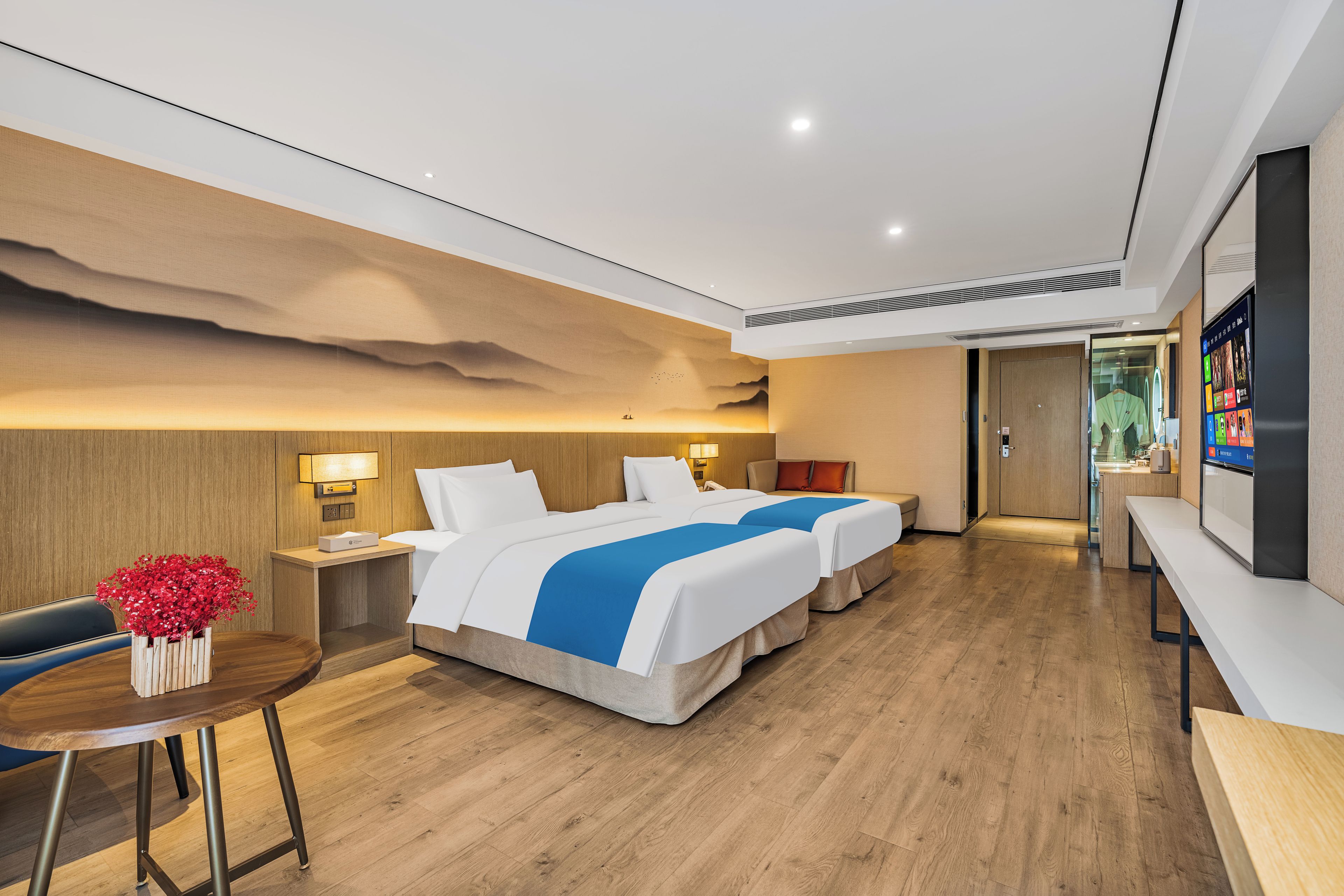 Une chambre d’hôtel avec un grand lit, des tables de chevet, un bureau et une chaise.