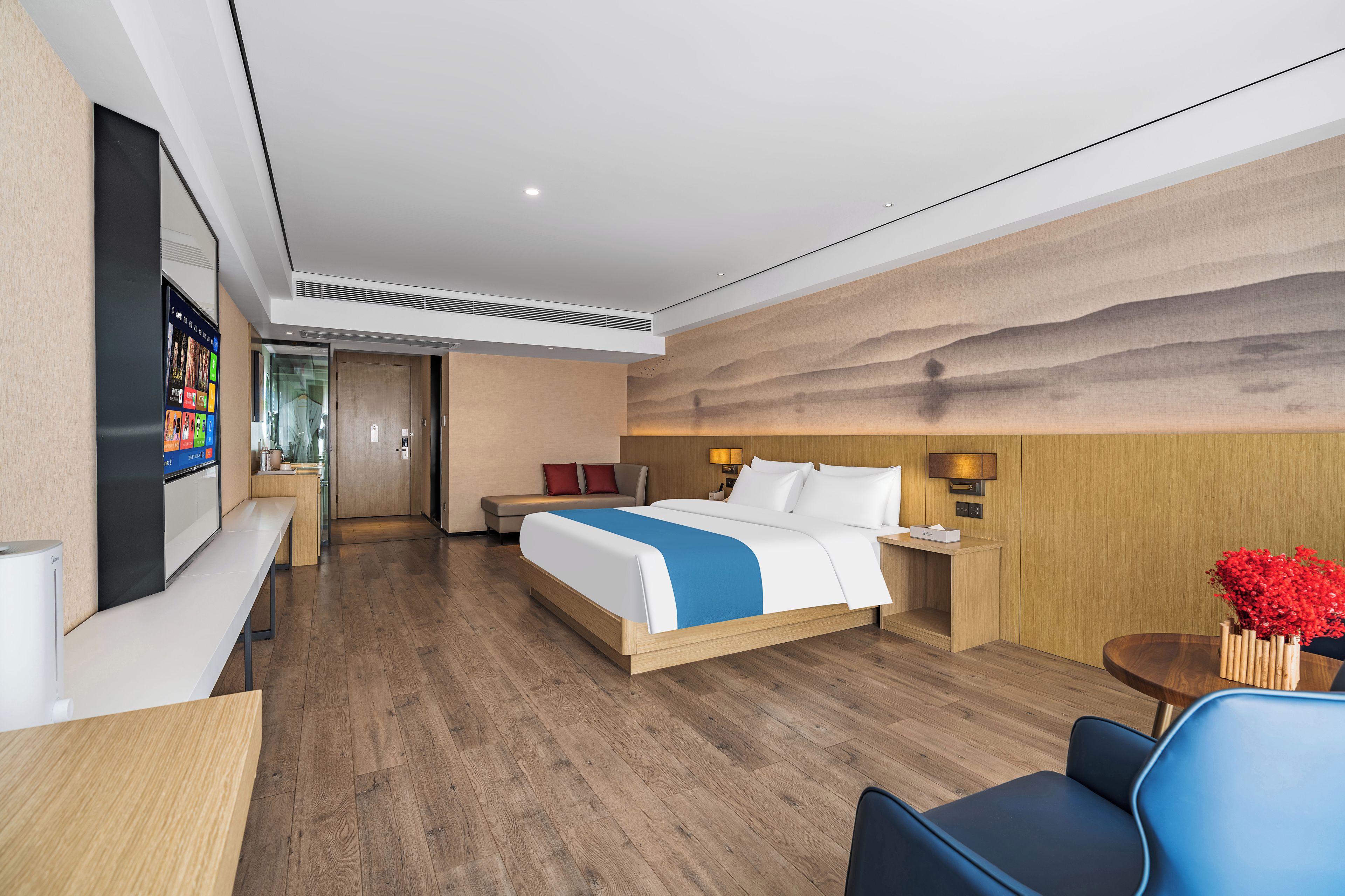 Une chambre d’hôtel comprenant un lit, des tables de chevet, un bureau, une chaise et un téléviseur.