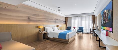 A modern hotel room with a large bed, a desk, a chair, and a television.