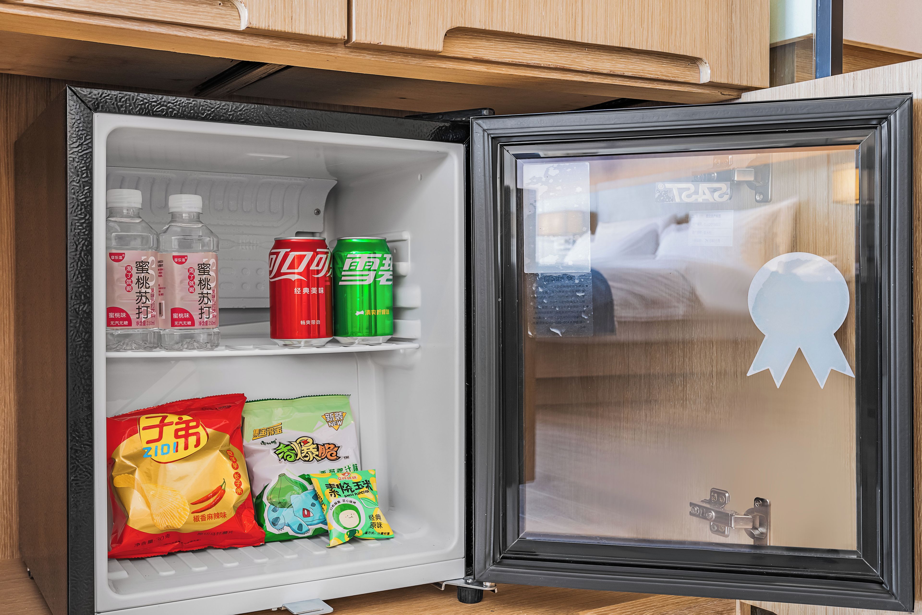 Un refrigerador con bebidas, aperitivos y un adorno.