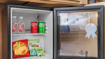 Un refrigerador con bebidas, aperitivos y un adorno.