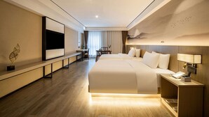 A modern hotel room with a large bed, bedside table, and a flat-screen TV mounted on the wall. - Ramada Encore by Wyndham Kunming Guandu (Kunming)