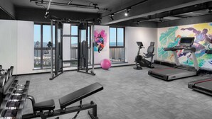 A modern gym with exercise equipment, large windows, and a city view. - Ramada Encore by Wyndham Kunming Guandu (Kunming)