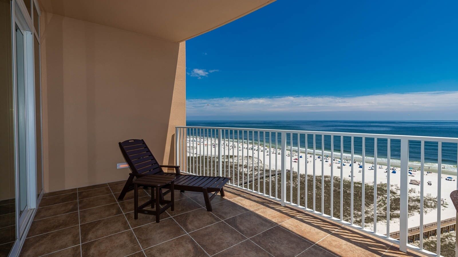 Un balcon avec vue sur une plage et l’océan.