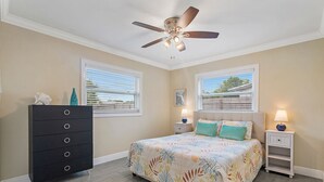 A bedroom with a bed, dresser, nightstands, and a ceiling fan. - 49th Ave Gem in Lealman area (St. Petersburg)