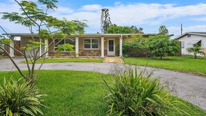A single-story house with a front porch, a small garden, and a clear sky. - 49th Ave Gem in Lealman area (St. Petersburg)
