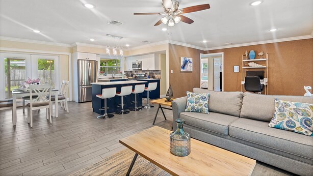 A modern kitchen with a central island, bar stools, and a ceiling fan. - 49th Ave Gem in Lealman area (St. Petersburg)