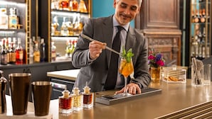 A bartender preparing a cocktail with a glass and a spoon. - Palazzo Roma - The Leading Hotels of the World (Rome)