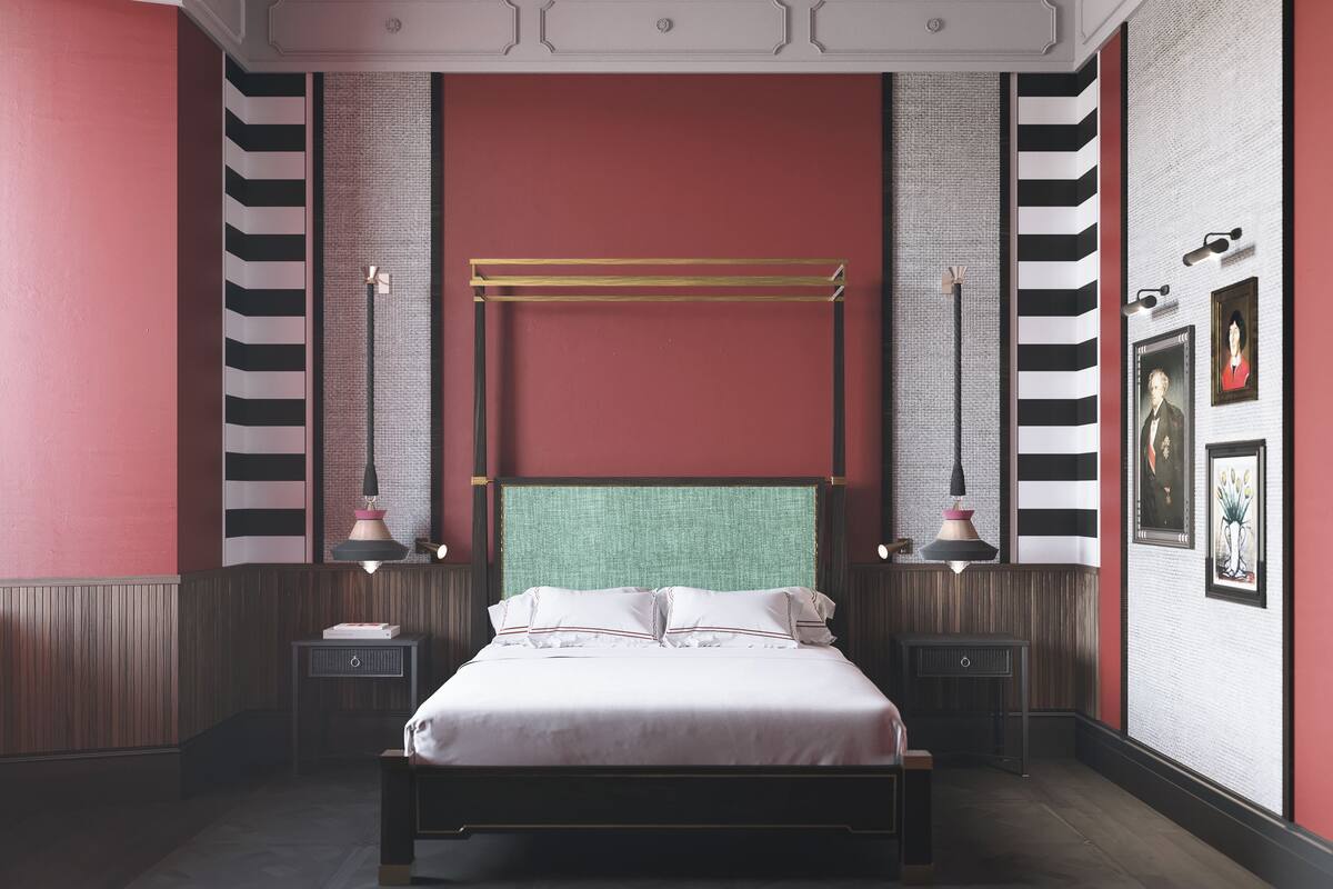 A bedroom with a large bed, two bedside tables, a green upholstered headboard, and striped wallpaper.