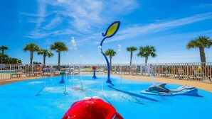 Ein Wasserpark mit Pool, Wasserstrahl-Attraktionen und einer auf Delfin gestalteten Wassersp installations.