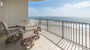 A balcony with a table and chairs, overlooking the ocean. - Phoenix West 807 3 Bedroom Condo (Orange Beach)
