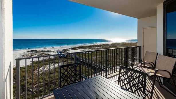 A balcony with a view of a beach and ocean.