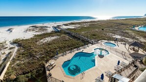 A resort with a large pool area, a beach, and a pier.