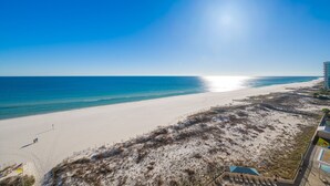 Une plage avec un ciel dégagé et un rivage sablonneux.