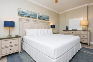 A neatly arranged hotel room with a large bed, two bedside tables with lamps, a dresser, and a painting above the bed. - Phoenix Orange Beach Ii 1603 2 Bedroom Condo (Orange Beach)