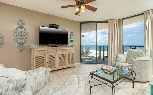 Relax in this stylish living room with a large flat-screen TV, comfortable sofa, and patterned armchair.