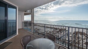 Uma varanda com vista para a praia e o oceano.
