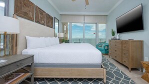 A bedroom with a bed, a dresser, a television, and a view of the sky. - Phoenix Orange Beach Ii 2202 3 Bedroom Condo (Orange Beach)