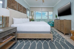 A bedroom with a bed, a dresser, a television, and a view of the sky. - Phoenix Orange Beach Ii 2202 3 Bedroom Condo (Orange Beach)