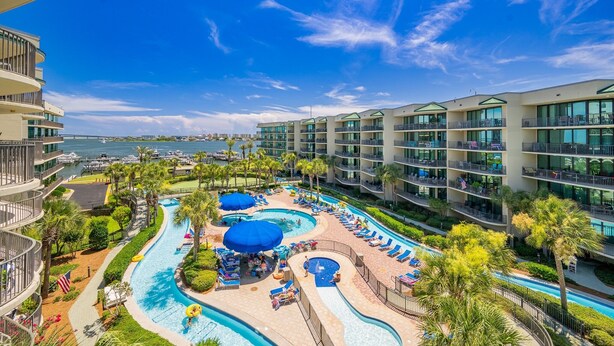 A hotel with a pool area, multiple balconies, and a view of the ocean.