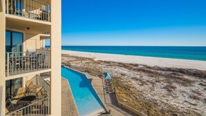 Un hôtel doté d’une piscine, offrant une vue sur la plage et comprenant plusieurs balcons.