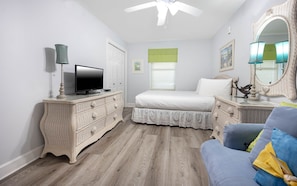 Relax in a serene bedroom with a comfortable bed, nightstands, and a ceiling fan for a restful stay.