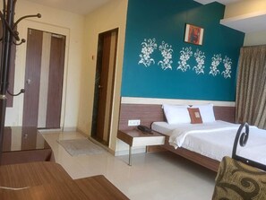 A hotel room with a bed, bedside table, and a desk. - Hotel Vegas (Khandala)